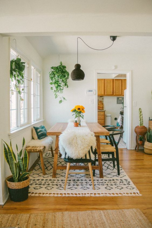 Boho chic in the dining room warm wood colors artificial fur green house plants nice ambience
