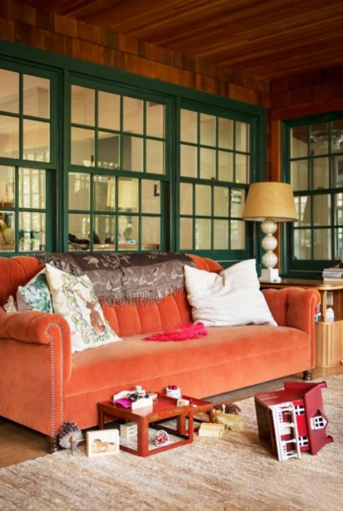 Trends in der Herbstdeko 2019 orangenfarbenes Sofa als Blickfang im Wohnzimmer