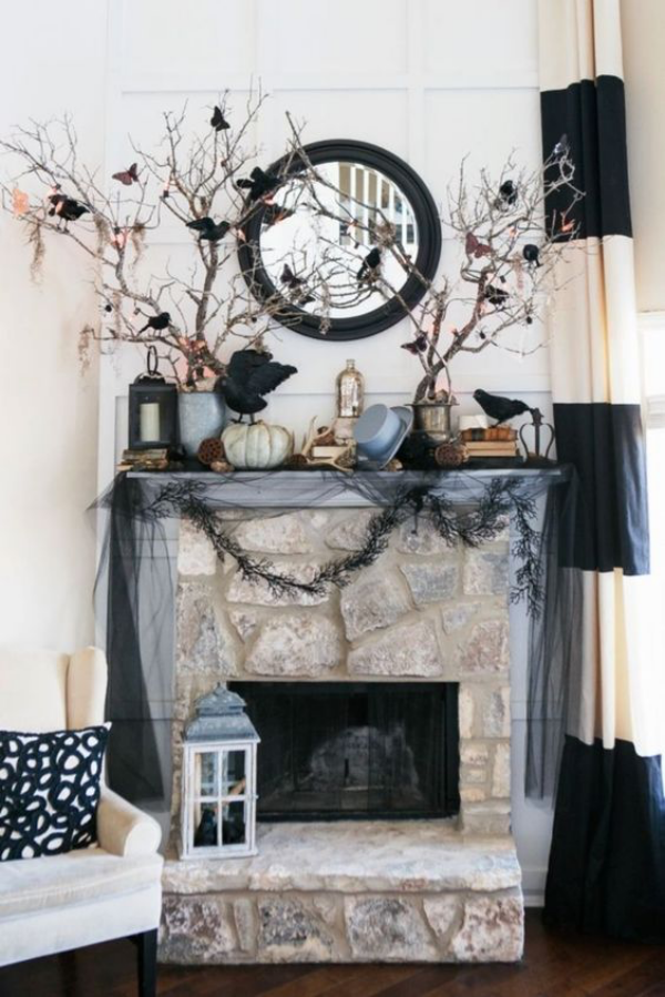 Halloween Deko im Wohnzimmer Steinkamin gruselig dekoriert Laterne Zweige schwarze Krähe