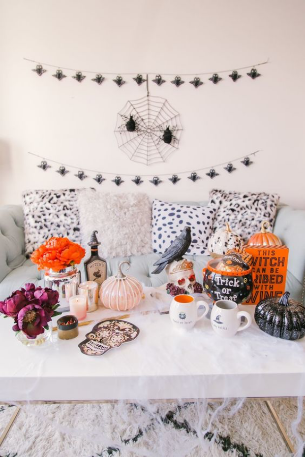 Halloween Deko im Wohnzimmer farbenfroher Tischschmuck Kerzen Kürbisse Blumen
