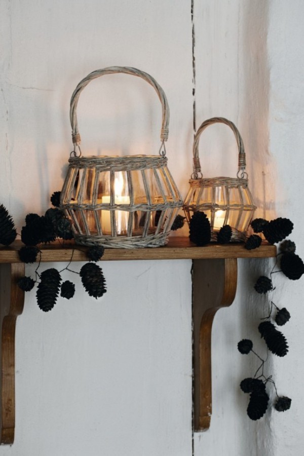 Skandinavische Herbstdeko zu Hause offenes Regal aus Holz rustikaler Look Flechtkörbe Kerzen Girlande aus Tannenzapfen