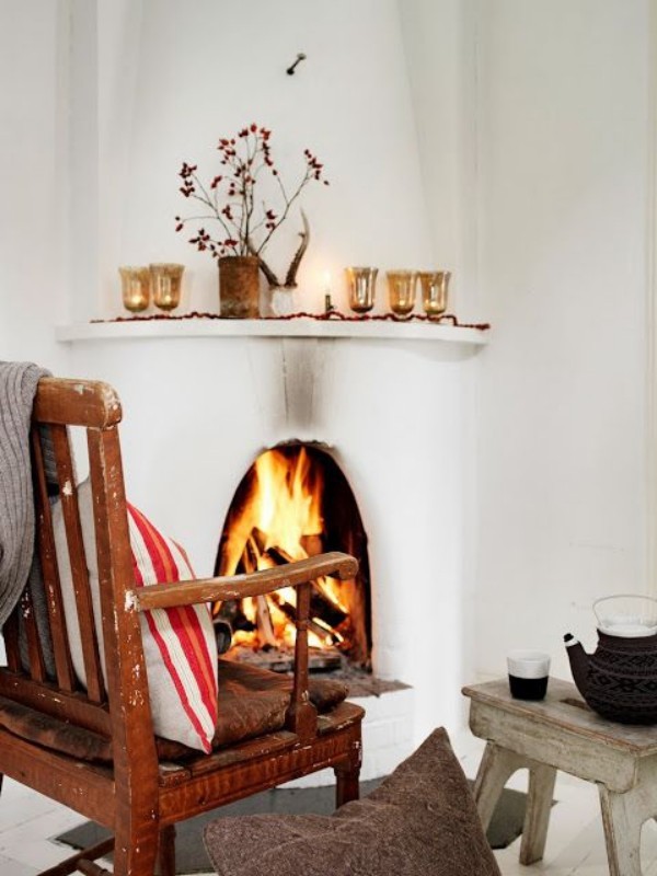 Skandinavische Herbstdeko zu Hause rustikales Ambiente Sessel vor dem Kamin Tee trinken in gemütlicher Atmosphäre