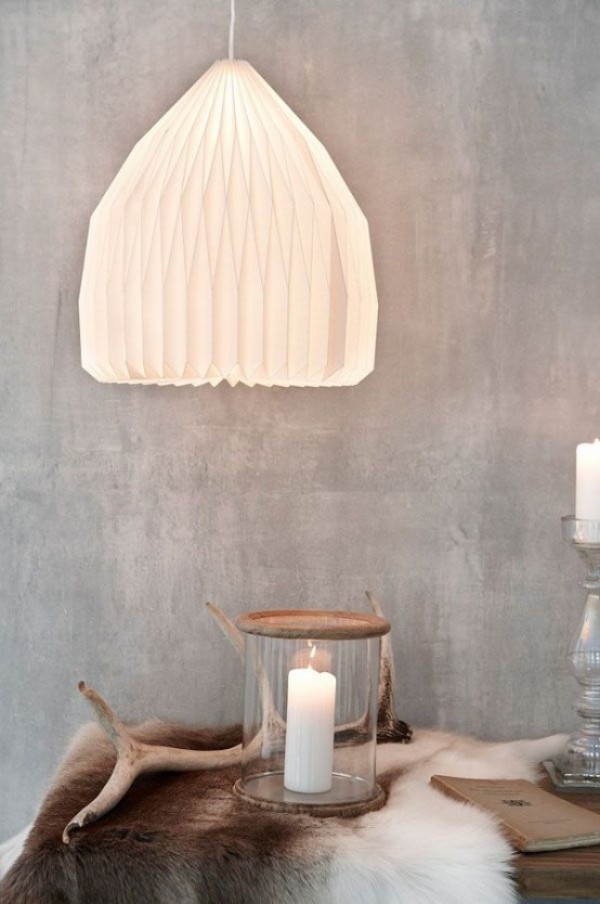 Skandinavische Herbstdeko zu Hause weiße Kerze Pelz Zweig unter der Lampe arrangiert