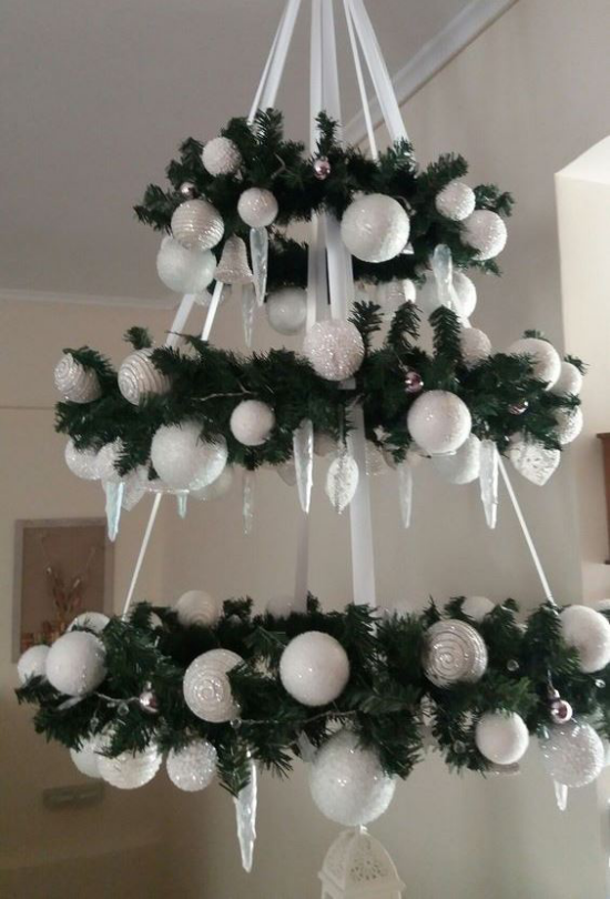 Christbaumornamente als Raumdeko Christbaum aus Tannengrün und weißen Weihnachtskugeln hängt von der Decke