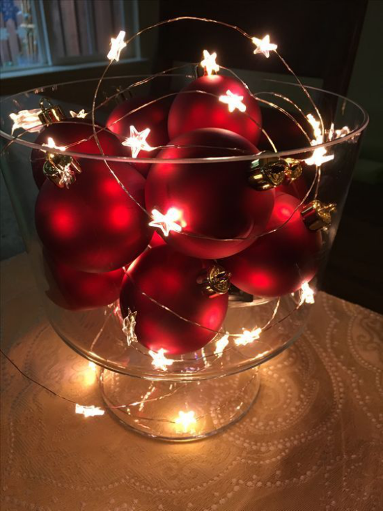 Christbaumornamente als Raumdeko glitzernde rote Weihnachtskugeln im großen Glas arrangiert