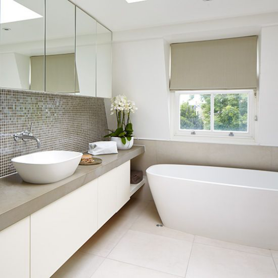 Hochwertiges Interieur elegantes Bad helle Farben weiße Badewanne weiße Blumen Waschtisch Spiegel