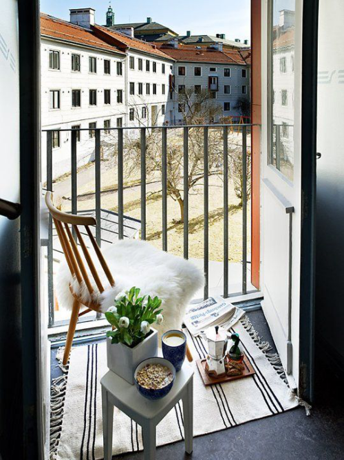 Balkon frühlingsfit machen kleiner Teppich Stuhl Pelzbezug Hocker Blumen Kaffeemaschine