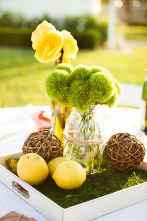 Frühlingsdeko mit Moos Vase mit Frühlingsblumen gelbe Narzissen gelbe Zitronen