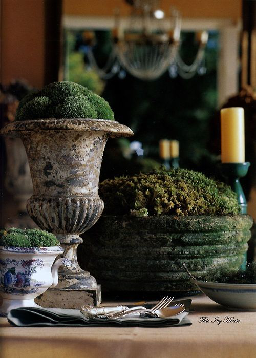 Frühlingsdeko mit Moos im Vintage Stil alte Pflanzbehälter dekoriert weiße Kerze im Hintergrund