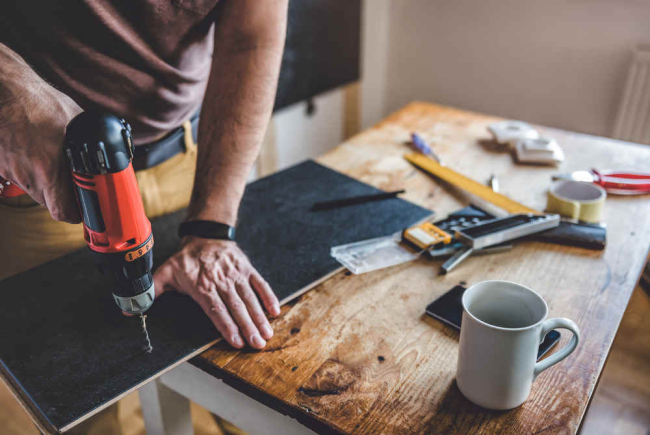 DIY Handwerken zu Hause gute Maschinen weitere Werkzeuge auf dem Tisch Kaffeetasse daneben