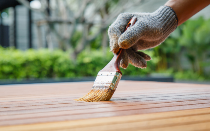Gartenmöbel reinigen Holztisch zuerst gründlich saubermachen dann Glasur auftragen Bürste Handschuhe