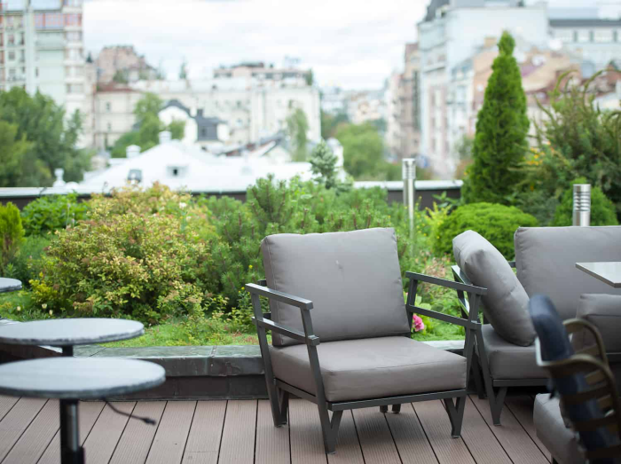 Moderne Terrassengestaltung trendige Einrichtungsideen bequeme Sitzmöbel auf der Terrasse in der Großstadt