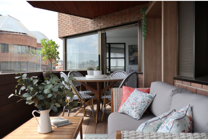 Moderne Terrassengestaltung trendige Einrichtungsideen in der Stadt Essecke bequeme Sitzecke Gießkanne grüne Zweige