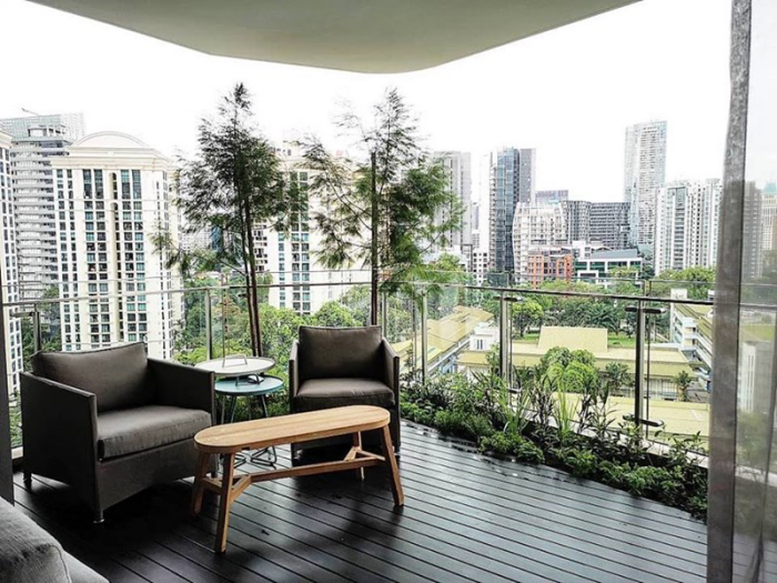 Moderne Terrassengestaltung trendige Einrichtungsideen zwei Sessel Holztisch Beet am Rande viel Grün