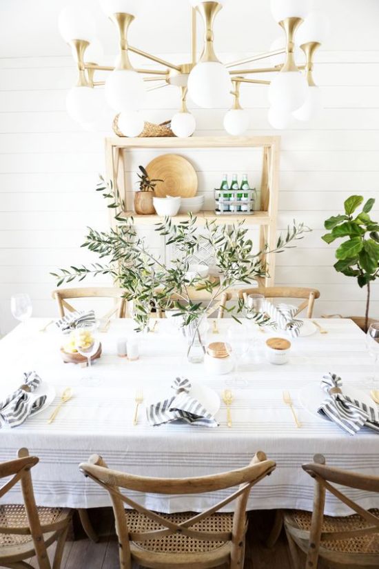Tischdeko Frühling ein einheitliches Konzept erarbeiten schlicht dekorierter Tisch weiße Tischdecke grüne Zweige Holz