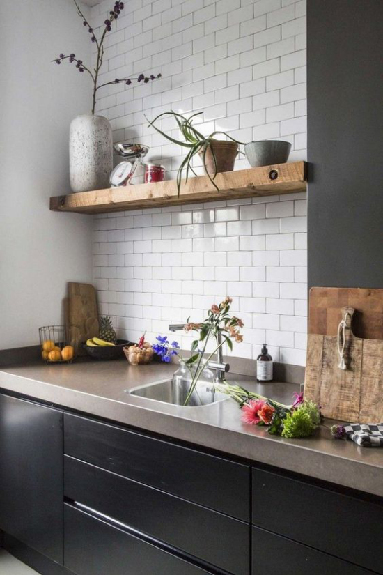 Küchenarbeitsplatten aus Beton dunkle Unterschränke oben weiße Metro Fliesen Regal aus Holz Blumentöpfe Vase