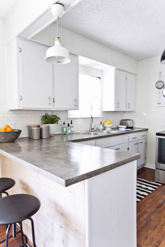 Küchenarbeitsplatten aus Beton einfaches Küchendesign L förmig Grau dominiert Hocker Schale mit Orangen