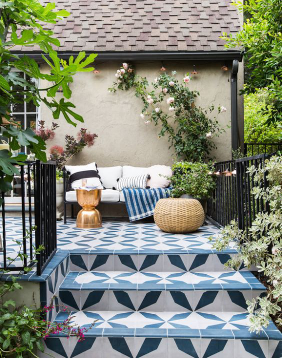 Outdoor Trends 2020 Terrasse stilvoll gestaltet Sofa weiche Kissen Hocker viel Grün Blumen gemusterte Keramik Treppe