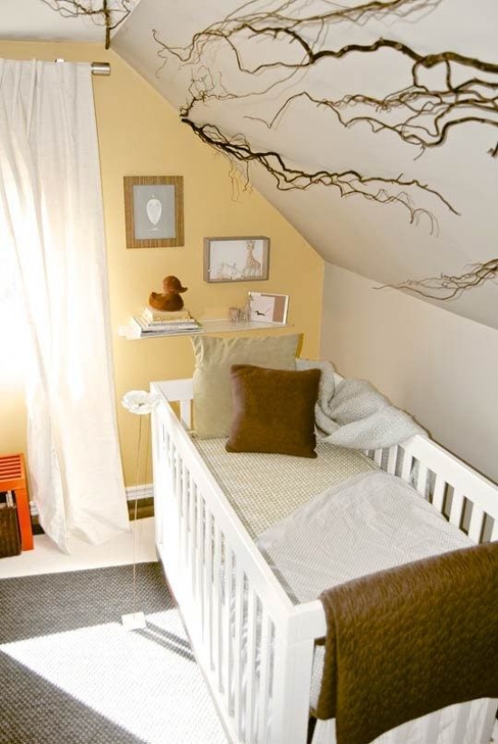 Babyzimmer mit Dachschräge Decke als Blickfang mit Ästen dekoriert Akzentwand in gelb