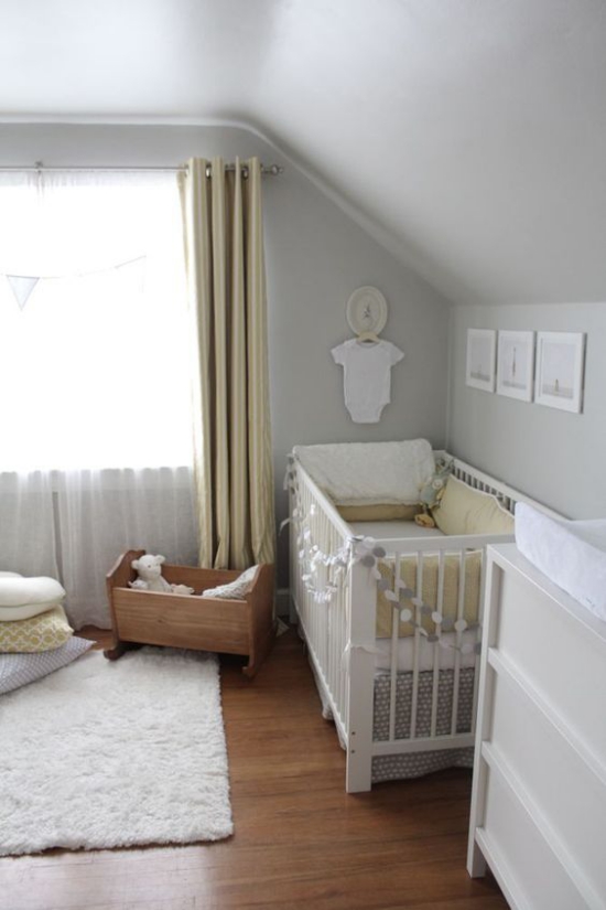 Babyzimmer mit Dachschräge Kinderbett rechts weißer Teppich Fenster gut geordnet hell sauber