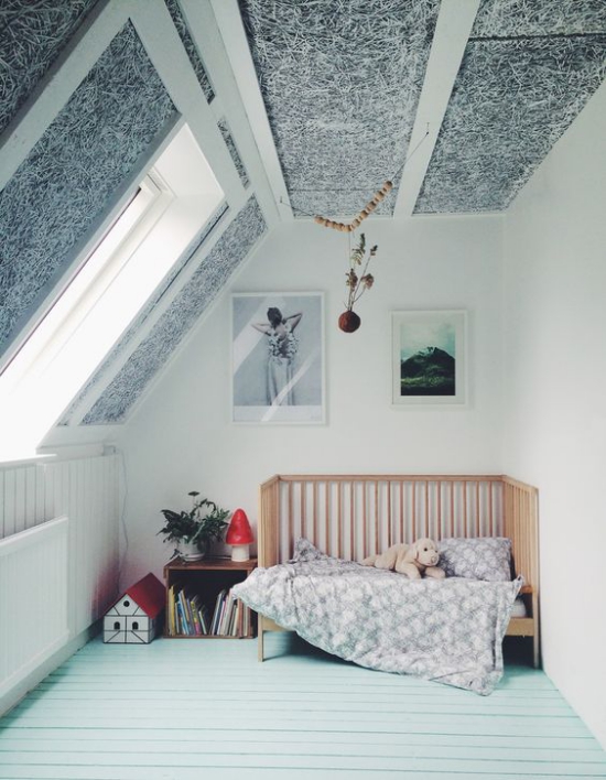 Babyzimmer mit Dachschräge einfache Einrichtung Bett zwei Wandbilder Tapete an der Decke sehr attraktiv