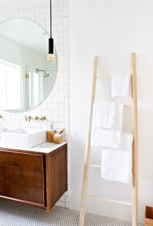 Handtücher platzsparend im Bad aufbewahren angelehnte Holzleiter weiße Tücher