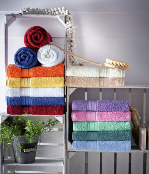 Handtücher platzsparend im Bad aufbewahren bunte mehrfarbige gefaltete Tücher auf Regalen