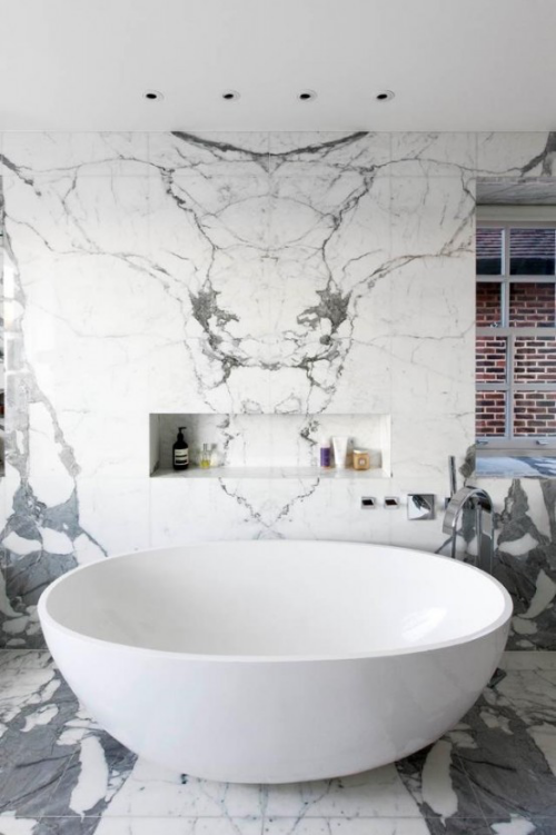Marmor im Bad starke Präsenz Marmorwand weiße Badewanne vorne eingebaute Deckenbeleuchtung