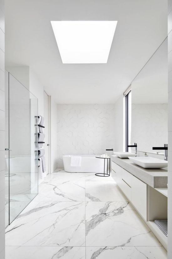 Moderne Badezimmer im minimalistischen Stil Dachfenster viel natürliches Licht Bad ganz in Weiß weißer Marmor schwarze Badarmaturen