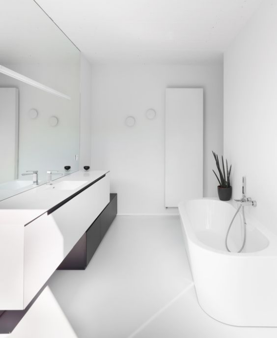 Moderne Badezimmer im minimalistischen Stil Weiß Schwarz in Kontrast Badpflanze Bogenhanf im schwarzen Blumentopf weiße Badewanne