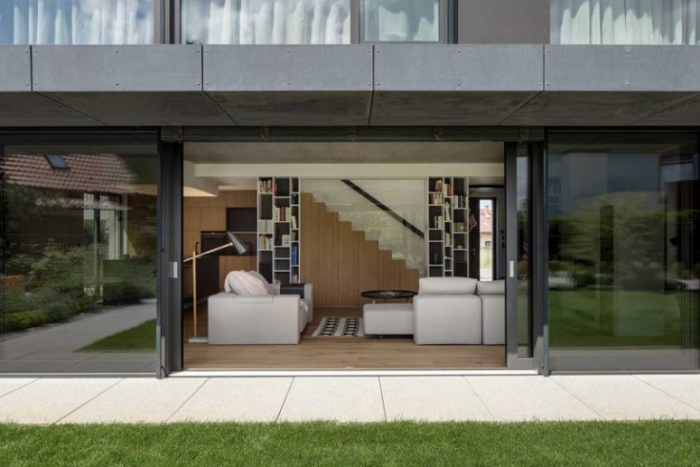 Einfamilienhaus offener Grundriss neutrale Farbpalette Glastüren im Erdgeschoss schieben direkter Zugang nach draußen