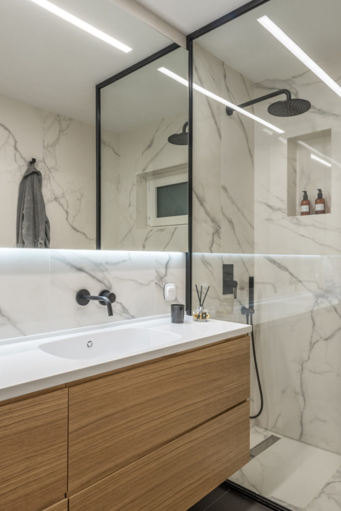 Minimalismus trifft Klassik Gästebadezimmer weißer Marmor schwarze Armaturen visueller Kontrast Glaswand Dusche Waschtisch Holzschrank