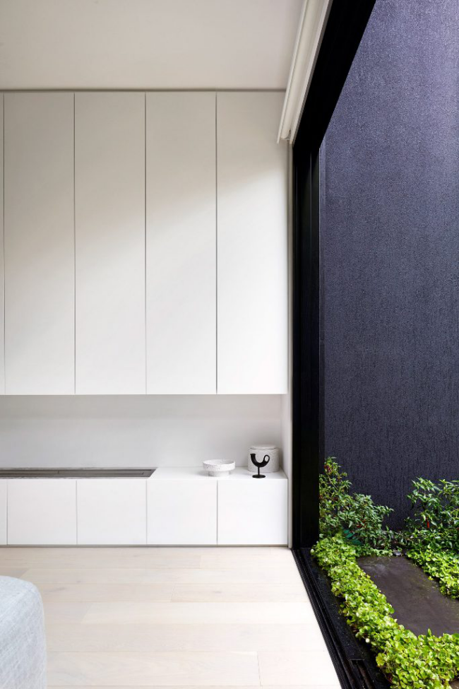 Minimalistisches Design Haus in Melbourne Wohnzimmer eingebaute Schrankwand in weiß sehr gute Staumöglichkeiten sorgt für beste Ordnung