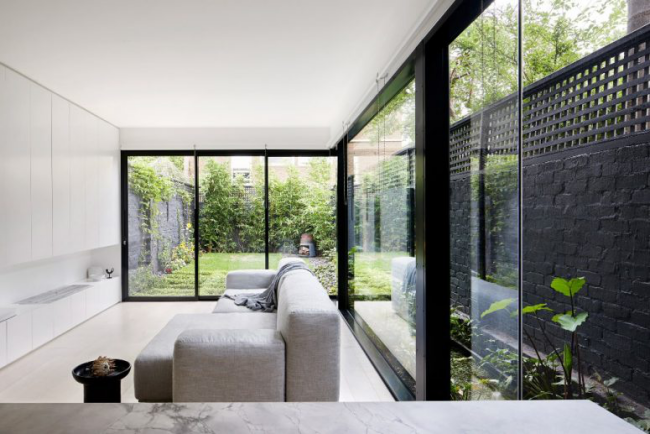 Minimalistisches Design Haus in Melbourne minimalistisch designtes Wohnzimmer deckenhohe Fenster herrlicher Blick auf den Innenhof