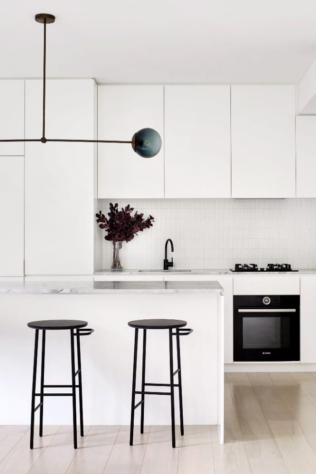 Minimalistisches Design Haus in Melbourne moderne Küche weiße Fronten schwarze Akzente Hocker