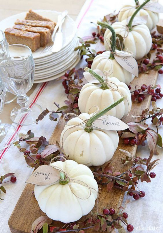 Herbstdeko mit Kürbissen weiße Baby Boo Kürbisse auf Holztablett in der Mitte ein festlich gedeckter Tisch
