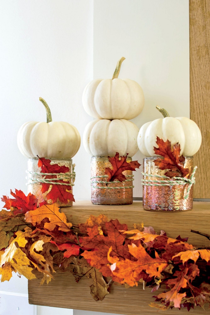Herbstdeko kinderleichte Ideen zum Nachmachen Schmuck für den Kaminsims drei Gläser kleine weiße Kürbisse Herbstlaub