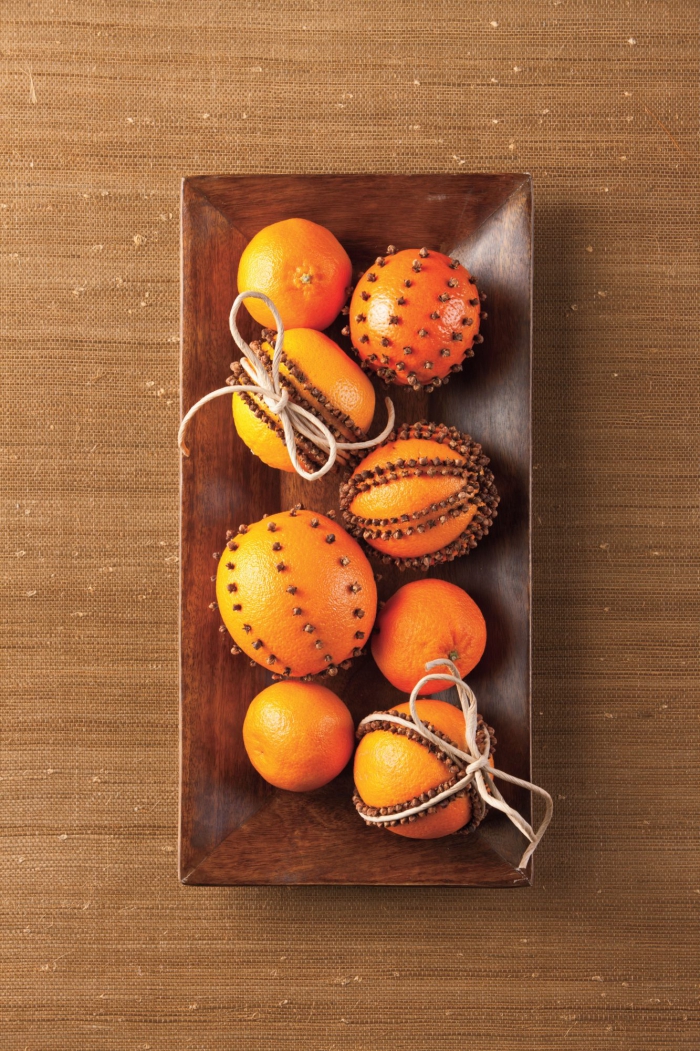 Herbstdeko kinderleichte Ideen zum Nachmachen orangefarbene Kürbisse geschmückt in einer Holzschüssel