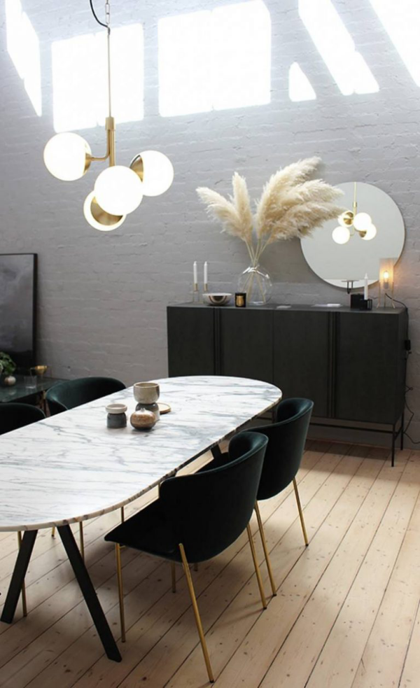 Pampasgras dekorieren minimalistisch eingerichtetes Esszimmer Esstisch Stühle Hängelampe Sideboard Vase mit Ziergras runder Spiegel
