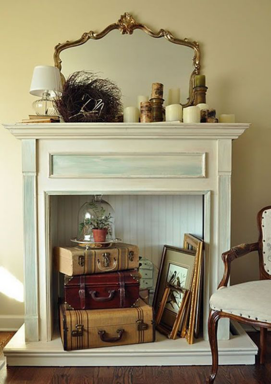 Stillgelegten unbenutzten Kamin dekorieren alte Koffer Spiegel Bildrahmen Vintage Stil im Wohnzimmer