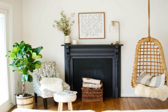 Stillgelegten unbenutzten Kamin dekorieren im Wohnzimmer Hängestuhl Sessel daneben einige Topfpflanzen gemütliche Atmosphäre rustikaler Touch