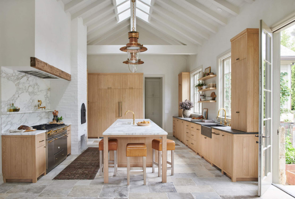 Küchentrends 2021 Marmor an der Küchenrückwand elegante Küchenschränke aus hellem Holz Boden mit Steinplatten belegt