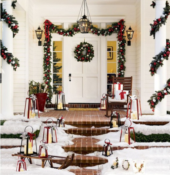 Weihnachtsdeko für draußen Hauseingang dekorieren viel Schnee Tannengrün Kranz Schlitten Laternen im Schnee