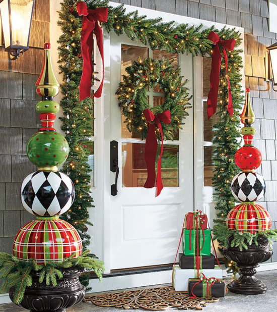 Weihnachtsdeko für draußen den Hauseingang schmücken traditionelle Farben Grün Weiß Rot verpackte Geschenke vor der Haustür große rote Schleifen