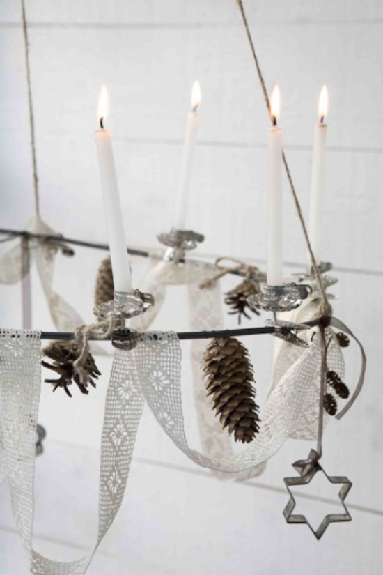 skandinavische Weihnachtsdeko Kronleuchter geschmückt gehäkeltes weißes Band weiße Kerzen Tannenzapfen