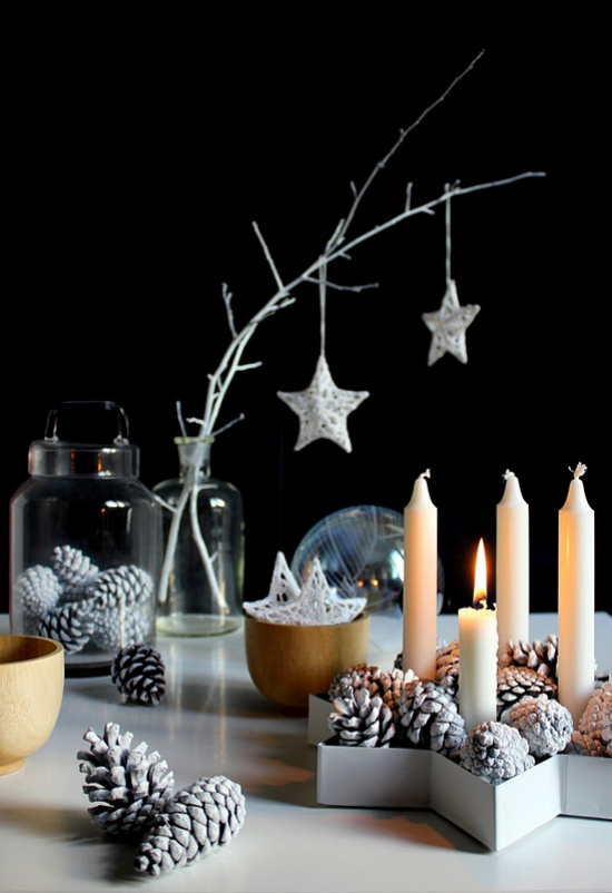 skandinavische Weihnachtsdeko Tannenzapfen weiß gefärbt Kerzen kahle Zweige im Glasgefäß Sterne