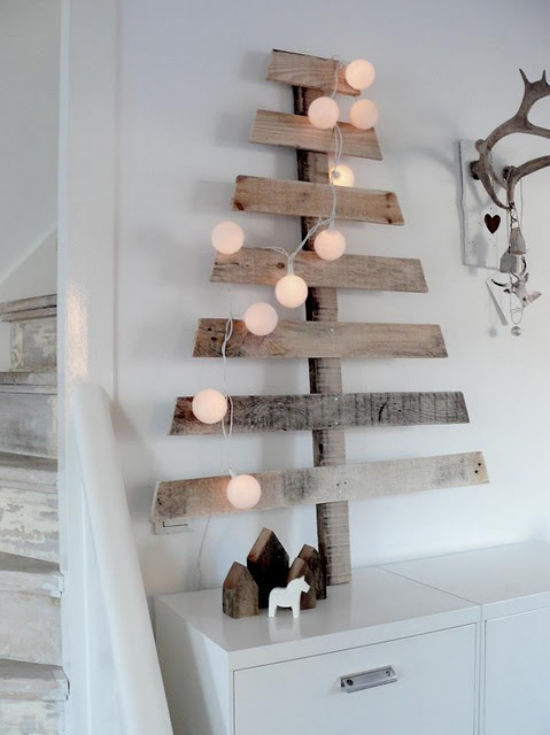 skandinavische Weihnachtsdeko Weihnachtsbaum aus Naturholz mit kleinen Lichtern geschmückt