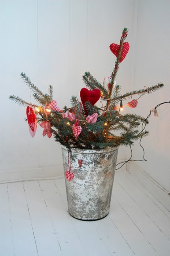 skandinavische Weihnachtsdeko kahle Zweige im Eimer mit selbstgebasteltem Schmuck Sterne rote Herzen