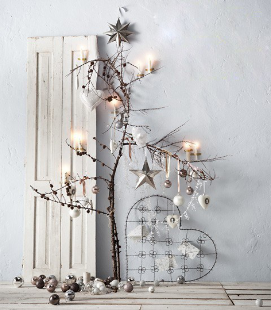 skandinavische Weihnachtsdeko kahle Zweige mit Lichtern und Sternen in Silberglanz geschmückt