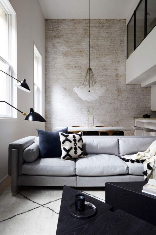 weiße Ziegelwand enges Wohnzimmer moderne Möbel Couch Lampen Hängeleuchte